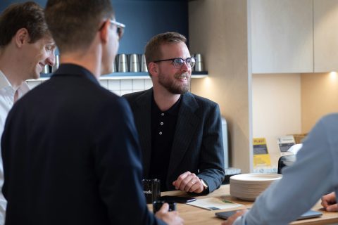 White men in active conversation in a casual work environment