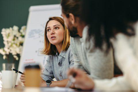 A woman leads a conversation in an office setting.