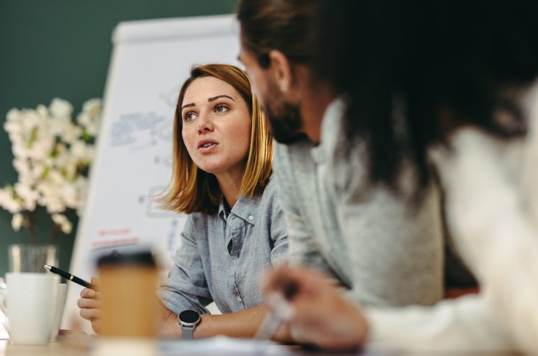 A woman leads a conversation in an office setting.